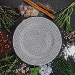 a plate surrounded by spices and herbs